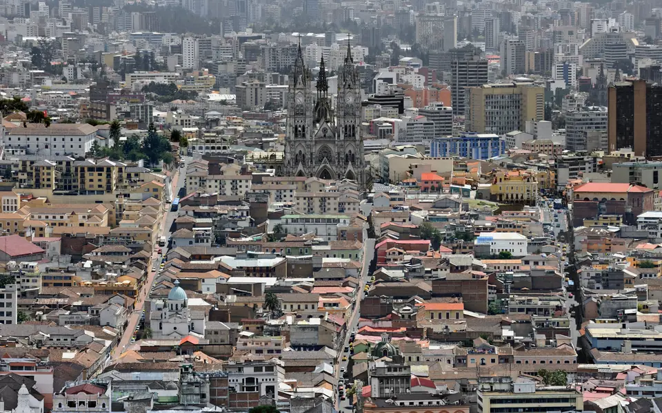 Quito desde lo alto: los tejados del centro histórico llenando el valle hasta los edificios altos del norte, con las dos torres de la Basílica del Voto Nacional en medio